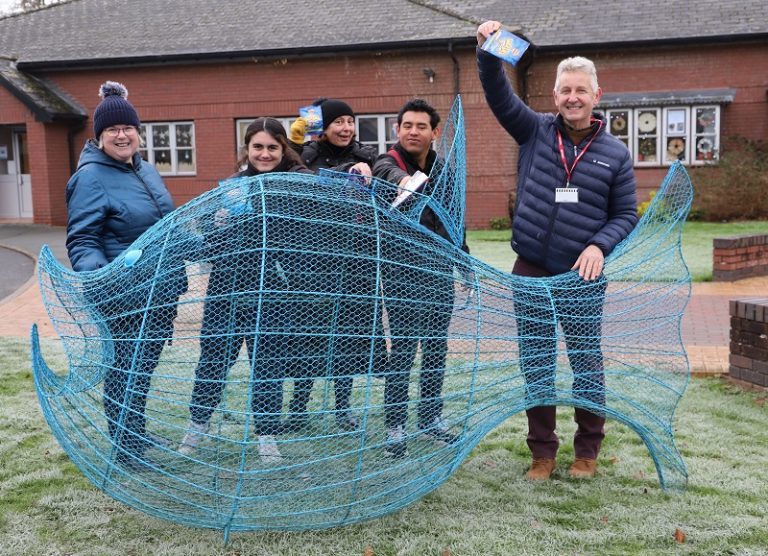 Helen Owen, Varvara Barbieri, Tabetha Crinson, Justin Harley and British Ironworks founder Clive Knowles stand behind a giant blue wire clown fish, holding up crisp packets ready to go into the fish.